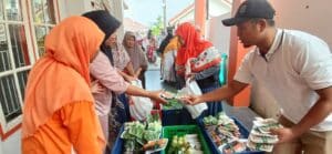 Ketua MPD dan Bendahara PKS Kota Cilegon dr. Hj. Shinta Wishnu W dan Ali Nurhasan turut melayani warga dalam program baksos pangan. (wartaglobalbanten/Maspri)
